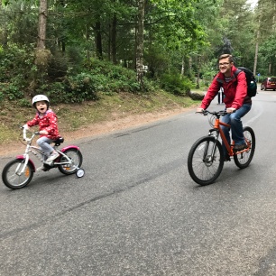 girl riding bike with daddy at center parcs